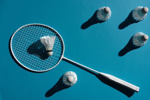 badminton racket and shuttlecocks badminton racket and shuttlecocks placed on blue surface badminton racquet stock pictures, royalty-free photos & images