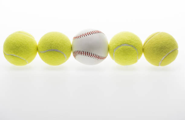 Closeup shot of tennis balls and one baseball ball isolated on white