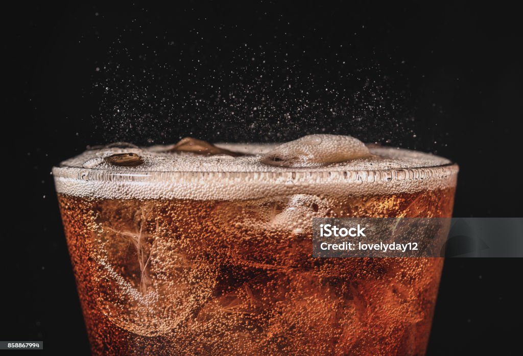 close up ice cola in glass and bubble soda splashing on black background Carbonated Stock Photo