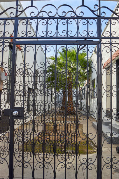 istock tall intricately fabricated metal gate leading into tropical courtyard 858885710