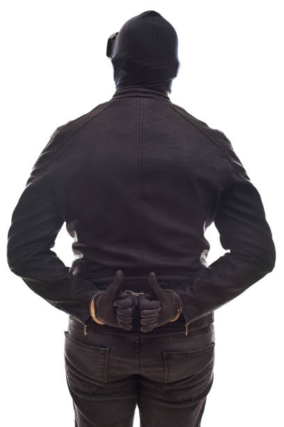 istock Dangerous criminal with handcuffs back view 858891452