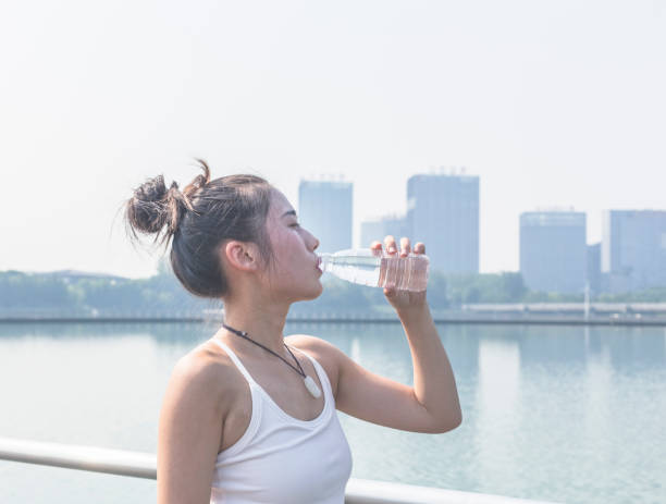 istock woman drinking water after yoga exercising 858895054