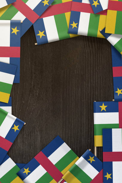 istock Central African Republic small flags framing a wood texture background with copy space 858899046