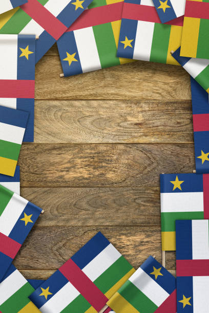 istock Central African Republic small flags framing a wood texture background with copy space 858899228