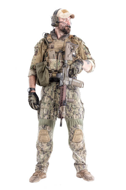 Special Forces Operator Full length low angle studio shot of special forces soldier in field uniforms with weapons, portrait isolated on white background. Tattoo on his forearm forearm tattoos men stock pictures, royalty-free photos & images