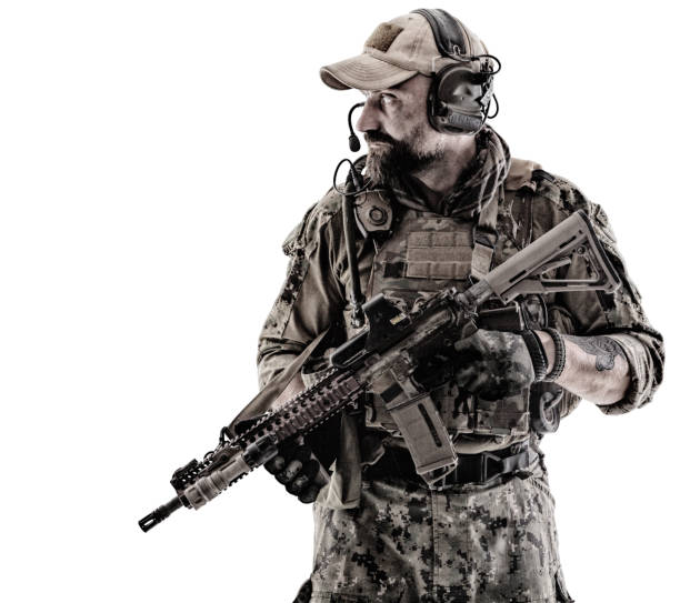 Special Forces Operator Half length low angle studio shot of special forces soldier in field uniforms with weapons on his shoulder, portrait isolated on white background forearm tattoos men stock pictures, royalty-free photos & images