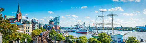 Hamburg Elbe waterfront Elbphilharmonie St Pauli Landungsbrucken city panorama Germany Panoramic view across the waterfront of central Hamburg, from the villas of Landungsbrucken past the iconic edifice of the Elbphilharmonie to the ships in the busy harbour of the Port of Hamburg, Germany. hamburg germany photos stock pictures, royalty-free photos & images