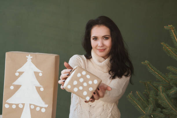 istock Happy young woman holding christmas present box 858928484
