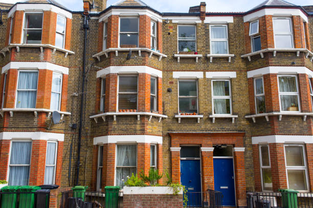 facciata di un edificio residenziale restaurato edoardiano in mattoni rossi e gialli con classiche vetrate e porte d'ingresso blu. - london england sash window house georgian style foto e immagini stock