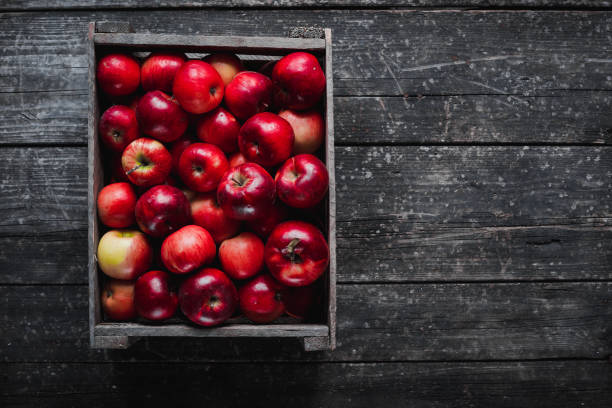 istock box with red apples on wooden board 858933062