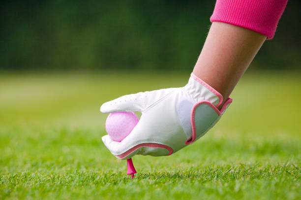 леди гольфист размещения розовый шар и тройник в землю. - golf women pink ball стоковые фото и изображения