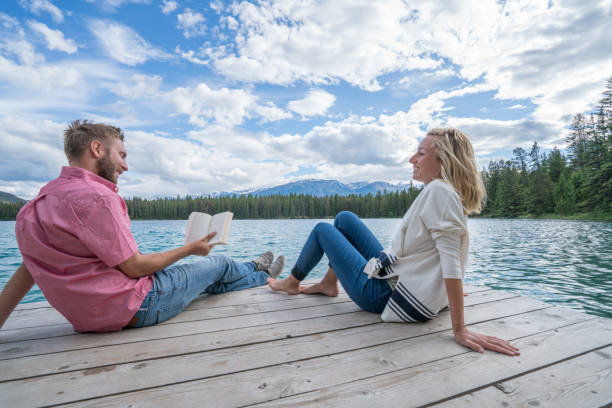istock Young couple relaxing on lake pier 858948872
