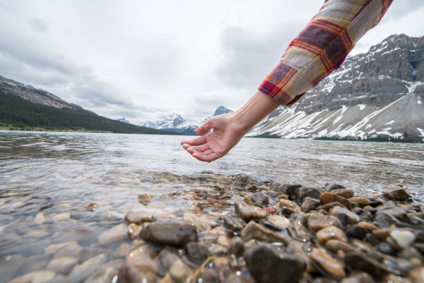 istock Human hand cupped to catch fresh water from mountain lake 858948932