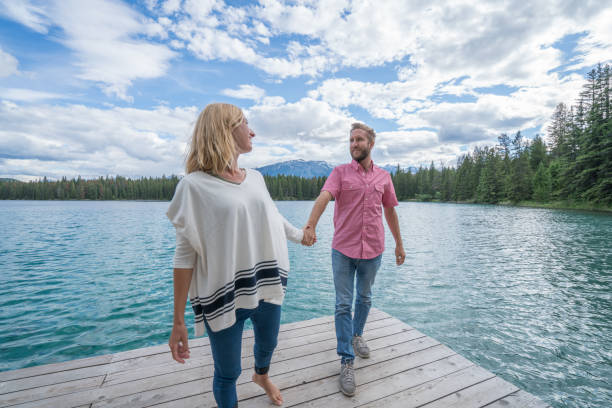 istock Young couple relaxing on lake pier 858949692