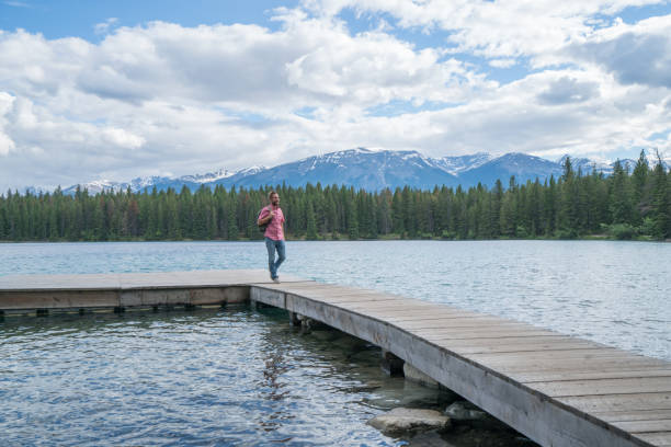 istock Young man walking on lake pier 858952308