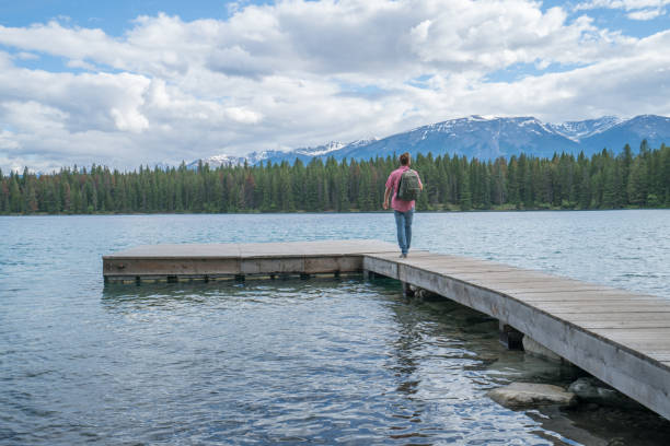 istock Young man walking on lake pier 858955108