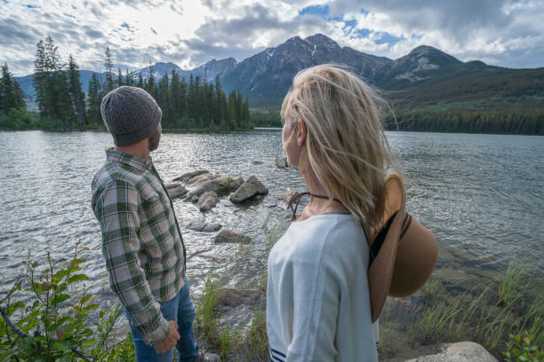 istock Young couple overlooking mountain lake 858957148