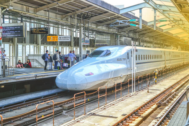 um trem-bala shinkansen param na estação de shin-osaka passageiros que espera a bordo, pessoas esperando o trem-bala shinkansen da manhã na estação de shin-osaka. - bullet train editorial transportation technology - fotografias e filmes do acervo