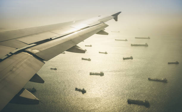 vista aérea de la flota de naves de carga industrial hacia el puerto de singapur en el sudeste asiático - retro en contraste dramático filtro - singapore shipping cargo container nautical vessel fotografías e imágenes de stock