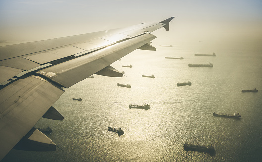Aerial view of industrial cargo ships fleet moving to the harbour of Singapore in south east Asia - Retro contrasted dramatic filter
