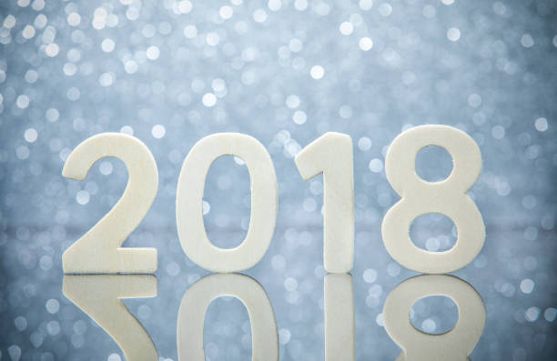 istock New year 2018 wood numbers reflection on glass table on silver 858966812