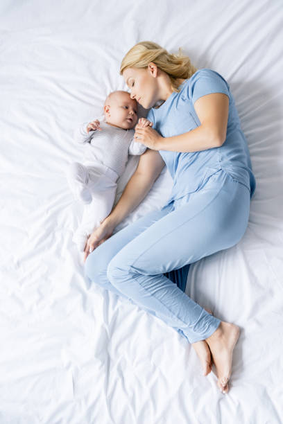 istock mother sleeping next to baby on bed 858967134
