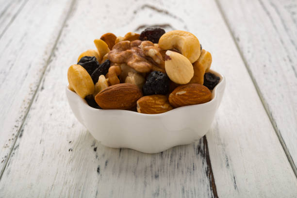 istock almonds and walnuts and cashew nuts and raisin and dry blueberries on a white dish 858967704