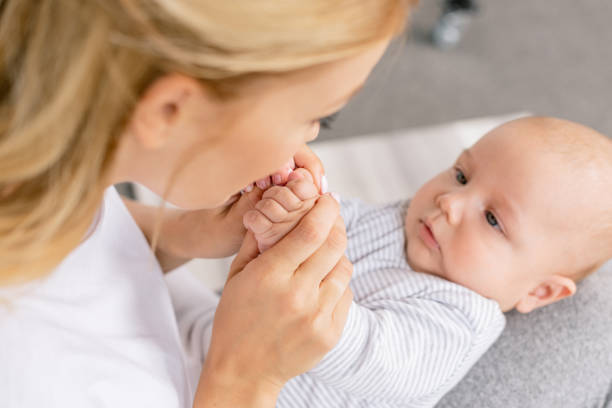 istock mother holding babys hands 858967860