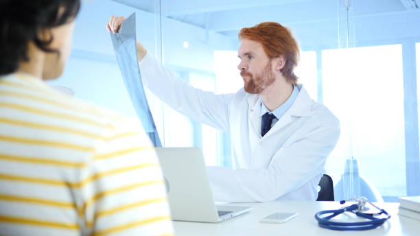 istock Upset Doctor Checking X-ray for Diagnosis, Sick Patient Sitting in Front 858971416