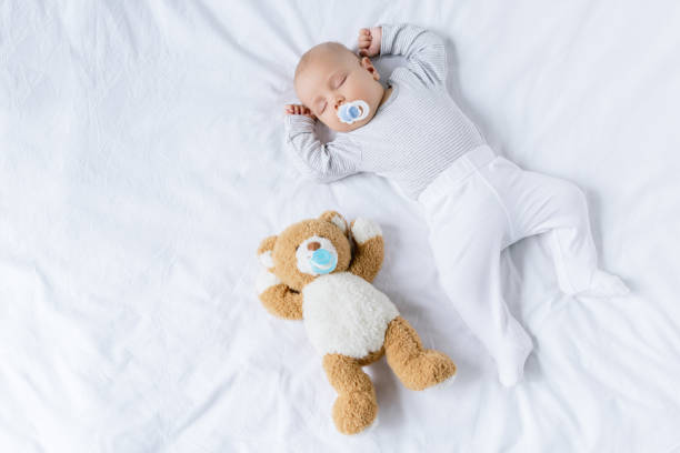 bambino addormentato con giocattolo - teddy bear baby toy stuffed animal foto e immagini stock