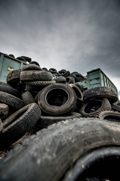 Stack of old car tires or wheels. Full frame shot of old, weathered tires. Monochrome toned image.