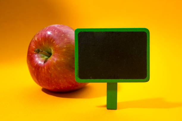 istock Blank price board with Red Apple on orange background. 858979254