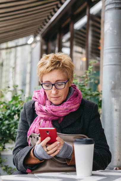 istock Smiling woman with phone in cafe 858982094