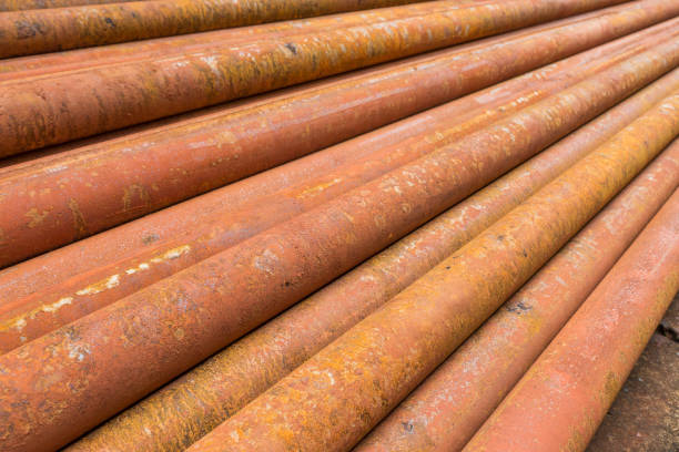 rusty metal tubes and pipes for construction and industrial use laying on heap stock photo