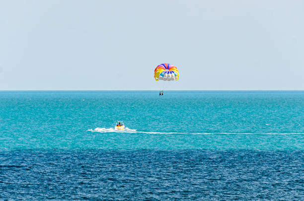 istock Colored parasail wing pulled by a boat in the sea water, Parasailing also known as parascending or parakiting 858992784