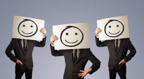istock Men in suit gesturing with sketched smiley faces on cardboard 858993690