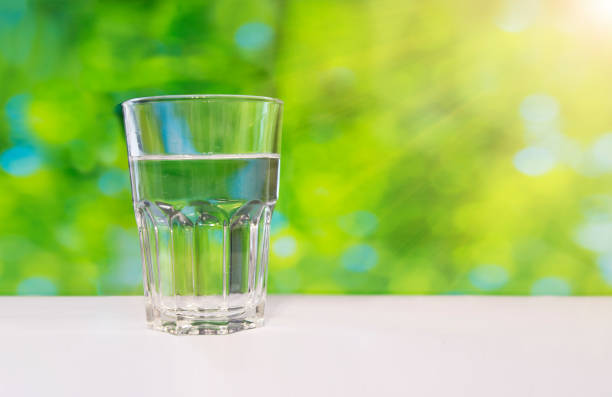 istock Faceted glass of water on nature background. 858997322