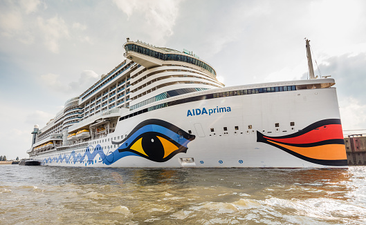 The huge cruise ship Aida prima in Hamburg harbour. This ship was built in 2016 and belongs to the latest ships in the cruise ship line. People on board are waiting for leaving the harbour to head towards the north sea.