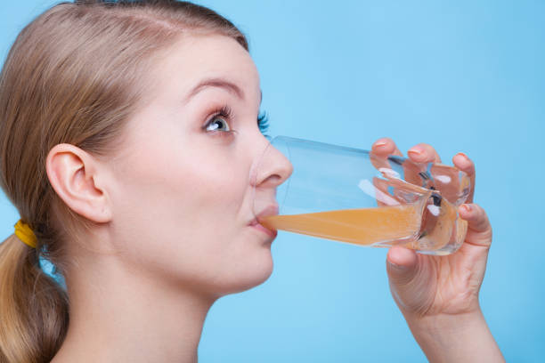 istock Woman drinking orange flavored drink or juice 859006078