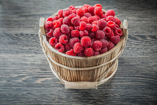 istock Raspberries in bucket on wooden board 859006376