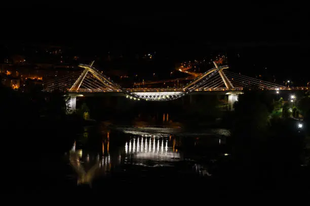 Night view of the modern Ponte do Milenio bridge over the Miño river in Ourense, Spain,