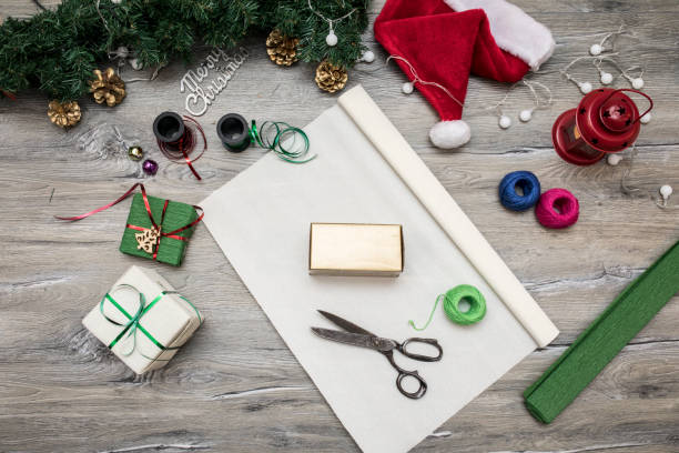 istock Packaging christmas present boxes . Top view of hands on white wood table with fir tree branches, decoration 859011370