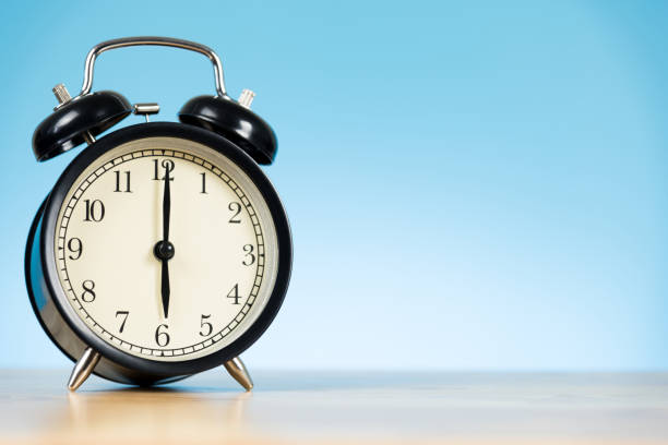 istock black alarm clock on the table and blue background 859029166