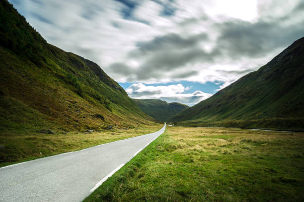 istock Straight mountain road leading through dramatic valley, Norway. 859047448