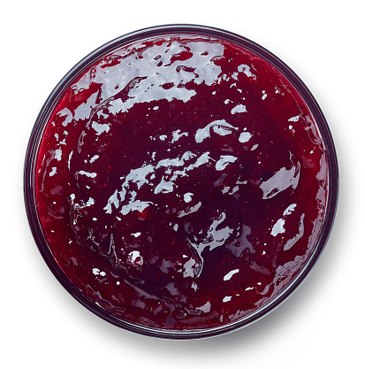 Bowl of cranberry jam isolated on white background from top view