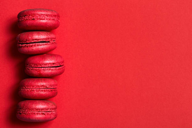 istock Cake macaroons on red background from above, almond cookies, top view 859066020