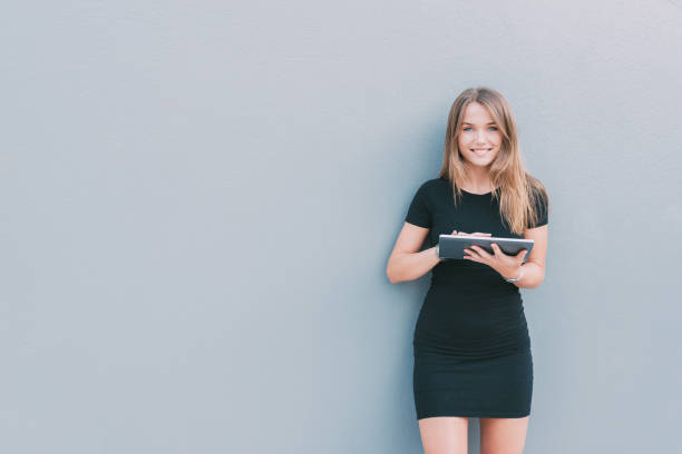 istock Happy young woman on the tablet by the wall 859068792