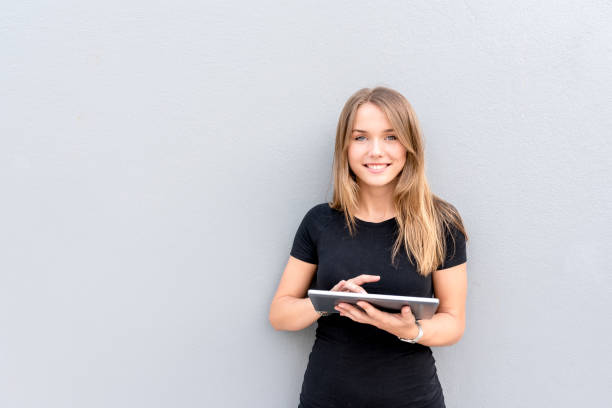 istock Happy young woman on the tablet by the wall 859068970