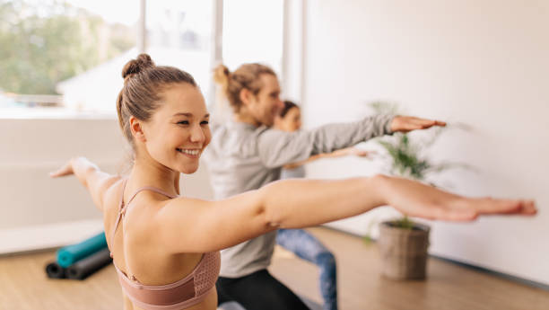 체육관 클래스에서 요가 연습 하는 여자 - stretching exercising men gym 뉴스 사진 이미지