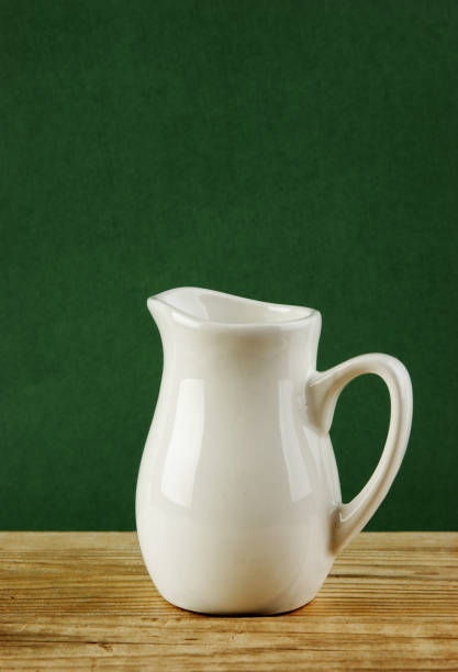Coffee maker, cups and croissants in the basket are on a round table in front of the window. Selective focus.